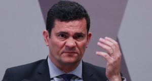 Sérgio Moro fazendo careta com a mão erguida