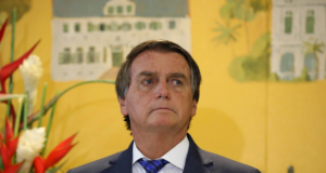 Foto de Bolsonaro com olhar pensativo, a cabeça está levemente inclinada para o lado direito da foto. Ele usa terno.