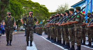 Militares em fileira segurando arma