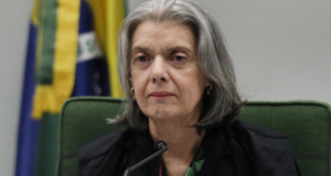 Foto de Carmén Lúcia com uniforme do STF, pele branca e cabelos brancos.