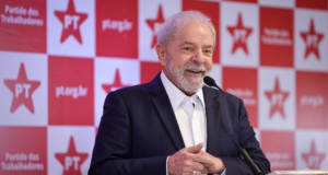 Foto de Lula sorrindo durante uma coletiva de imprensa.