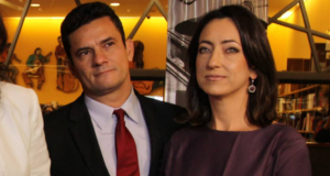 Foto de Moro e Rosangela com rousas de gala um ao lado do outro durante um evento.