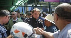 Foto de Bolsonaro arrodiado de diversos apoiadores em Brasília.