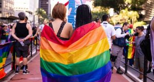 Duas mulheres de costas com a bandeira colorida