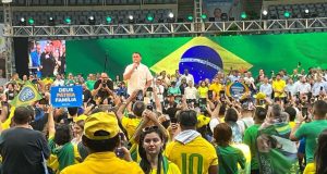 Jair Bolsonaro de camisa branca discursando perto de apoiadores