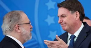 Augusto Aras e Jair Bolsonaro conversando, os dois de perfil