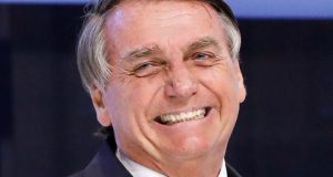 Jair Bolsonaro olhando para o lado e rindo