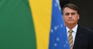 Jair Bolsonaro com bandeira do Brasil em segundo plano