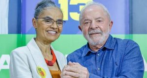 Marina Silva e Lula sorrindo e de mãos dadas