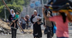 Pessoas caminhando em meio aos destroços em Gaza