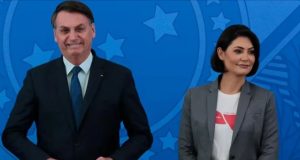 Jair e Michelle Bolsonaro sorrindo lado a lado, em pé