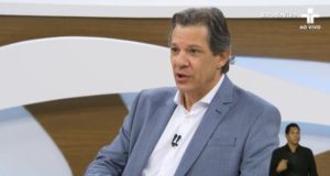 Fernando Haddad falando com expressão séria no estúdio do Roda Viva