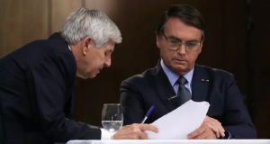 General Heleno e Jair Bolsonaro lado a lado, ambos com expressões sérias