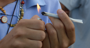 Mãos segurando e acendendo cigarro de maconha