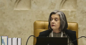 Ministra Cármen Lúcia com expressão séria, olhando para o lado, no canto direito de foto