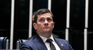 Sergio Moro de terno e gravata, olhando pra cima com expressão séria