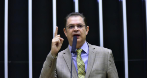 Deputado federal Sóstenes Cavalcante (PL-RJ) falando e gesticulando de terno e gravata, com expressão séria e óculos