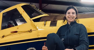 Juliana Turchetti sentada e sorrindo em avião amarelo